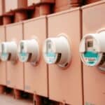 Řada elektroměrů s číselníky umístěná vedle sebe v detailním záběru