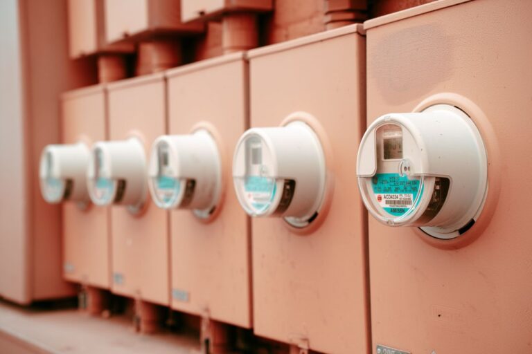 Řada elektroměrů s číselníky umístěná vedle sebe v detailním záběru