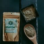 Kratomový prášek v misce a na dřevěné lžičce