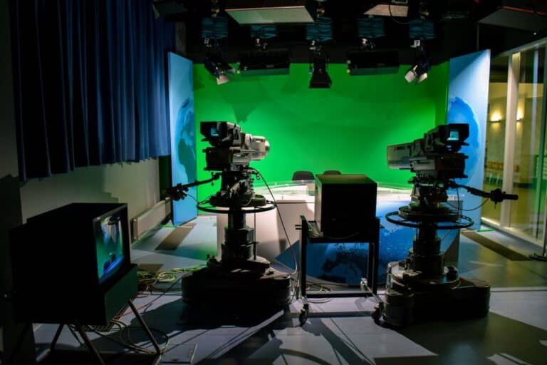 Televizní studio s kamerami a zeleným pozadím