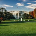 Bílý dům ve Washingtonu s fontánou na trávníku a podzimně zbarvenými stromy