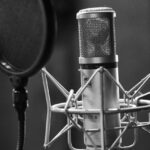 Studiový kondenzátorový mikrofon s pop filtrem, černobílá fotografie