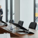 Zasedací stůl s mikrofony a monitory v jednacím sále