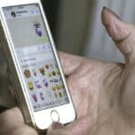 Ruka držící stříbrný mobilní telefon