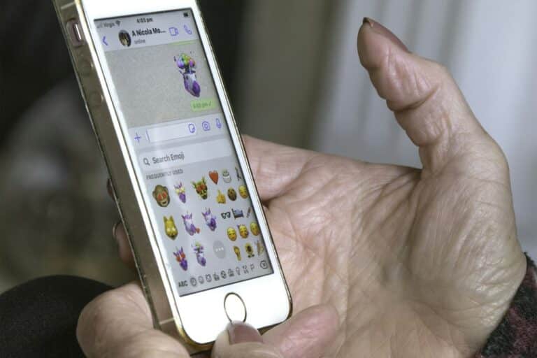 Ruka držící stříbrný mobilní telefon