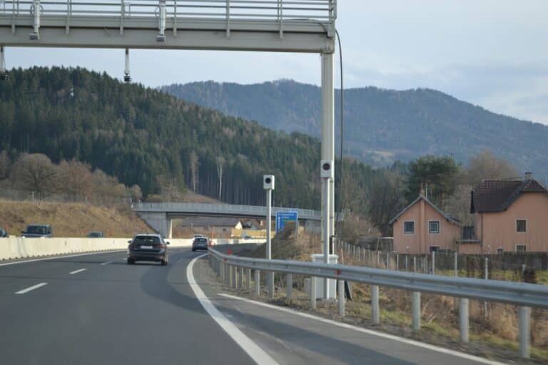 Auta na dálnici, v pozadí zalesněné kopce