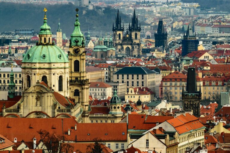 Barevné střechy a věže historické Prahy za denního světla