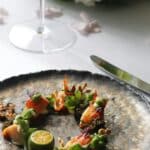 Talíř s jídlem na stole restaurace vedle sklenky vína
