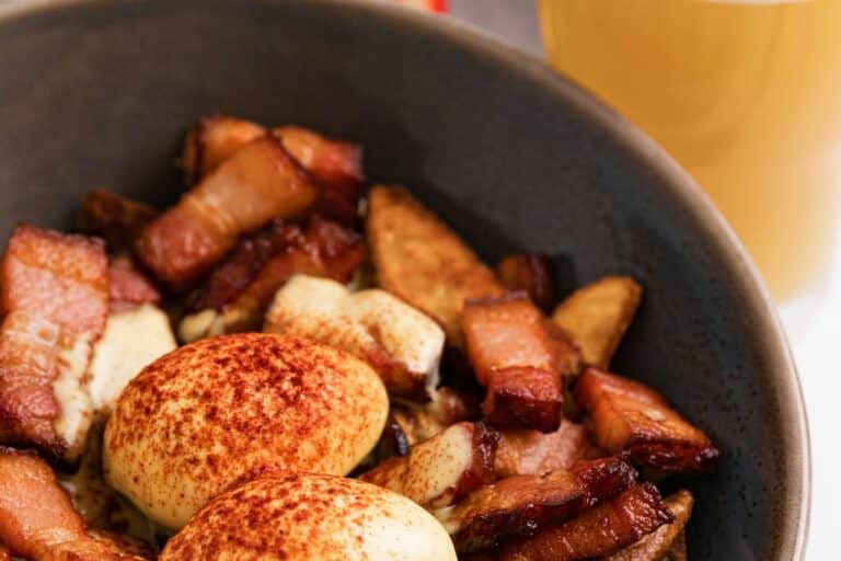 Miska se snídaní: zastřená vejce, slanina a ovoce